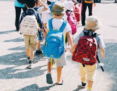 Children wearing sun hats and backpacks.