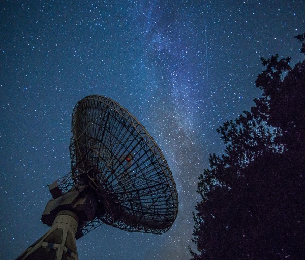 A large telescope at night, observing the stars.