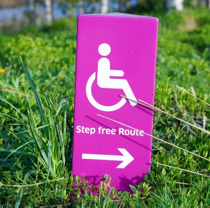 A sign with a wheelchair symbol, which says step free route.